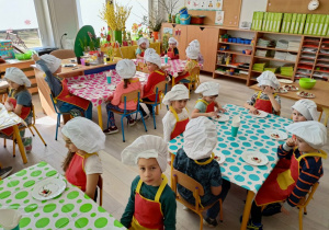 Dzieci przy stolikach podczas degustacji deseru.